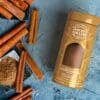 Cinnamon sticks and powder in a golden container.