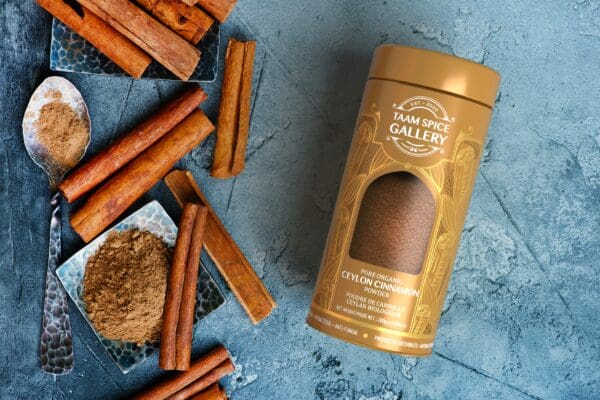 Cinnamon sticks and powder in a golden container.