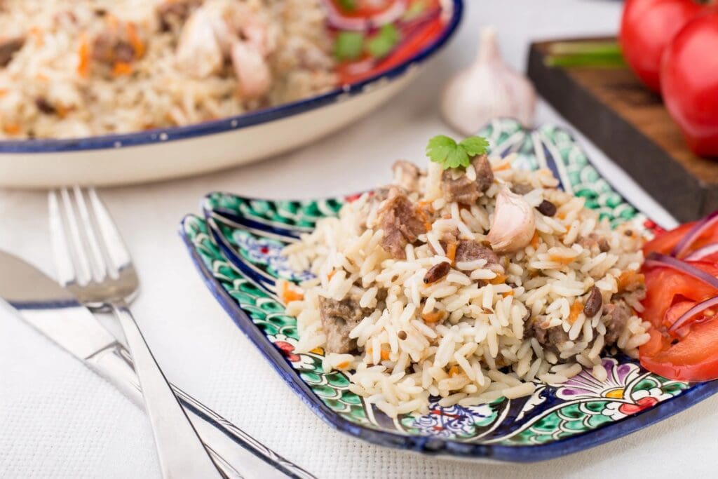 A plate of Uzbek pilaf with meat and vegetables.