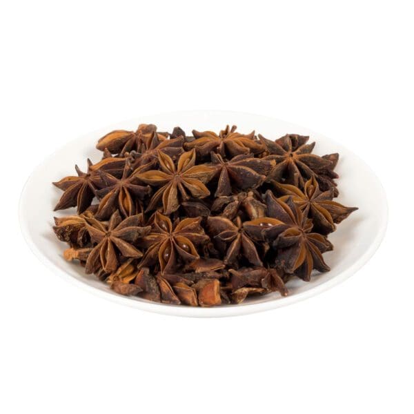 Star anise spice on a white plate in color.