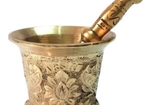 A brass mortar and pestle with floral engravings.