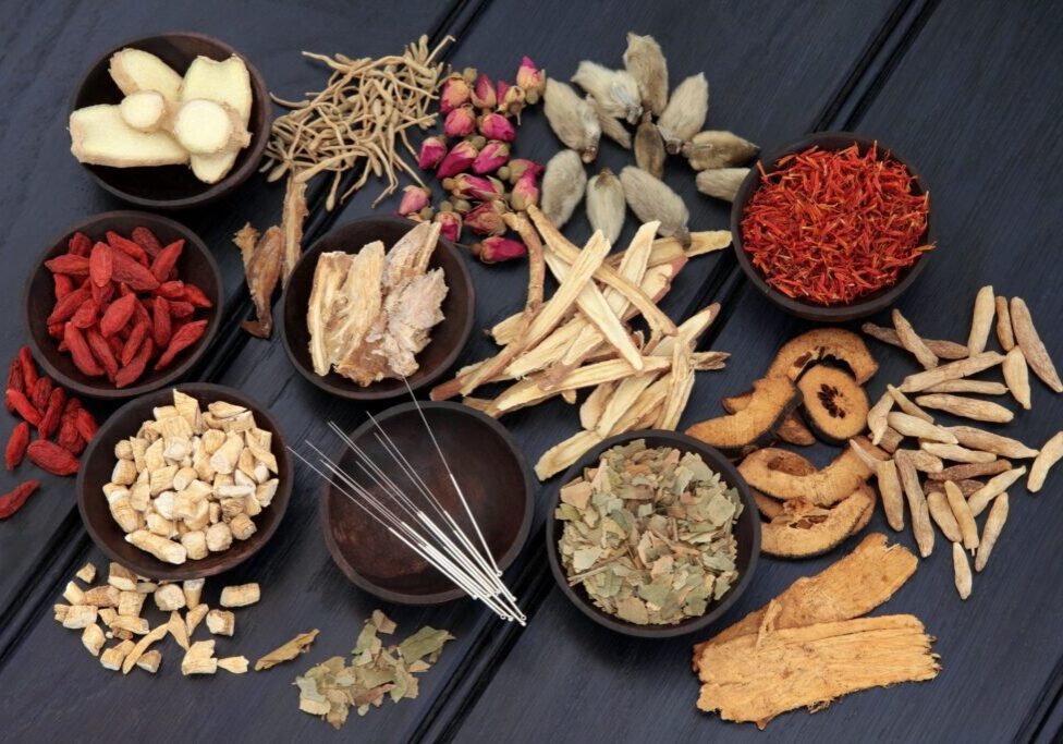 Various dried herbs and spices in wooden bowls.