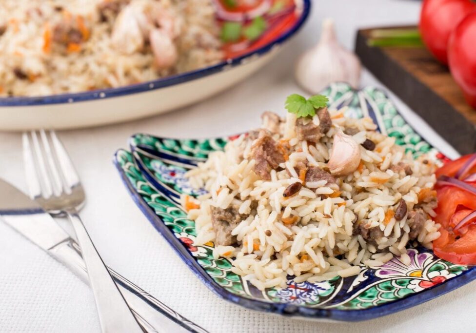 A plate of Uzbek pilaf with meat and vegetables.